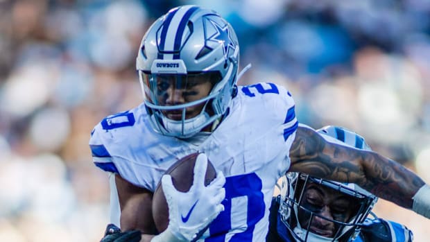 Cowboys running back Tony Pollard runs through a linebacker.